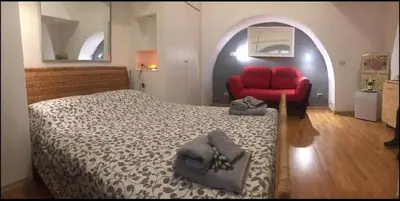 a bedroom with a bed and a red couch at Cenci Rome Centro Storico in Rome