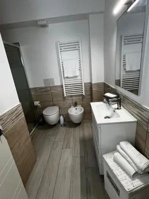 a bathroom with a sink and a toilet and mirror at Elegant & Spacious 2BR 2BA Unit with Private Patio in Rome