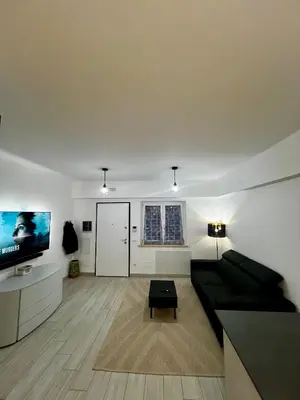 a living room with a black couch and a flat screen tv at Elegant & Spacious 2BR 2BA Unit with Private Patio in Rome