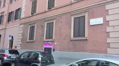 a pink building with cars parked in front of it at Coral flat Colosseo in Rome
