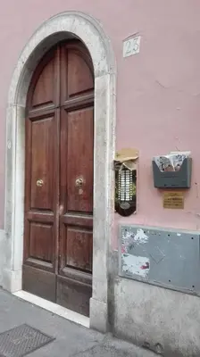 a wooden door on the side of a pink building at Coral flat Colosseo in Rome