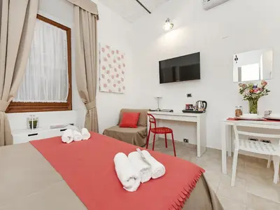 a bedroom with a red bed with white towels at Coral flat Colosseo in Rome