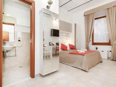 a bedroom with a bed and a bathroom with a sink at Coral flat Colosseo in Rome