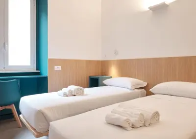 two beds in a room with towels on them at Station To Station Rome Ensuite Rooms in Rome