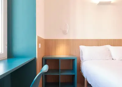 a bedroom with a bed and a table and a chair at Station To Station Rome Ensuite Rooms in Rome
