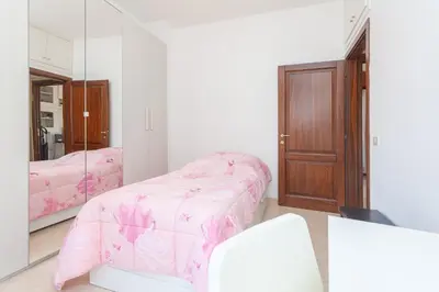 a bedroom with a pink bed and a mirror at LIVI20 Apartment Gemelli in Rome