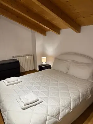 a bedroom with a white bed with two towels on it at Kejsi Home in Rome