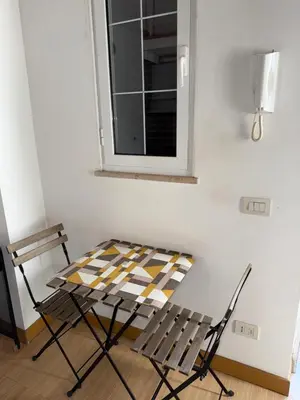 a table and chair in a room with a window at Kejsi Home in Rome