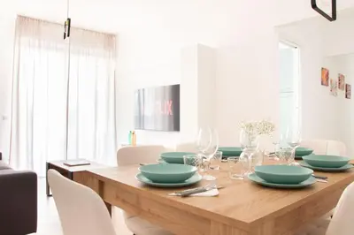 a dining room with a wooden table with plates and glasses at Luxury & Design Apartment Piramide in Rome