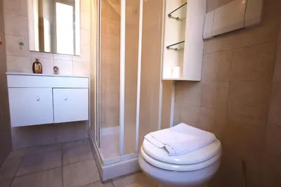 a bathroom with a white toilet and a shower at San Giovanni Holiday Home in Rome