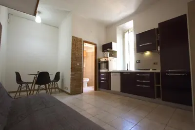 a bedroom with a kitchen and a table and chairs at San Giovanni Holiday Home in Rome