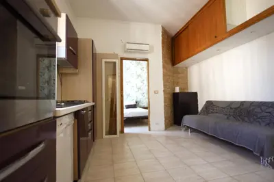 a kitchen and living room with a couch in a room at San Giovanni Holiday Home in Rome