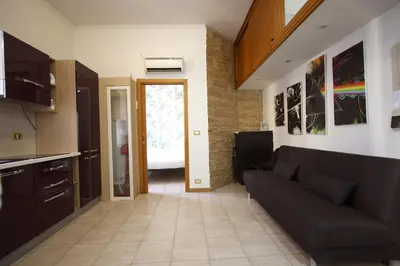 a living room with a couch and a kitchen at San Giovanni Holiday Home in Rome