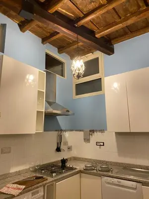 a kitchen with white cabinets and a ceiling with a chandelier at Artist apartment in the heart of Trastevere in Rome