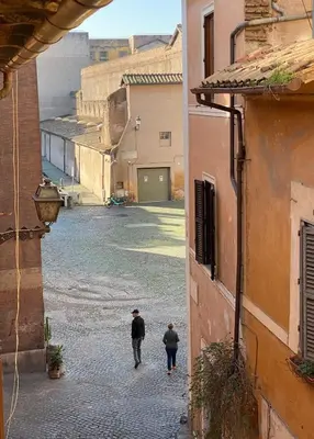 two people walking down a street in an alley at Artist apartment in the heart of Trastevere in Rome