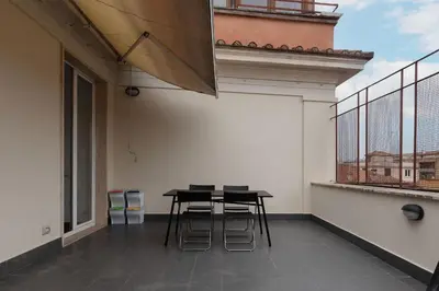 a patio with a table and chairs on a balcony at GuestHost - Trastevere Station Bright Apartment with Terrace in Rome