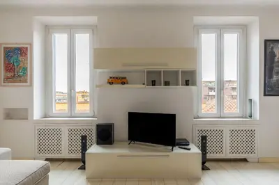 a living room with a tv and three windows at GuestHost - Trastevere Station Bright Apartment with Terrace in Rome