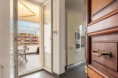 a door leading to a kitchen with a balcony at GuestHost - Trastevere Station Bright Apartment with Terrace in Rome