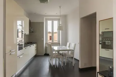 a kitchen with a table and chairs in a room at GuestHost - Trastevere Station Bright Apartment with Terrace in Rome