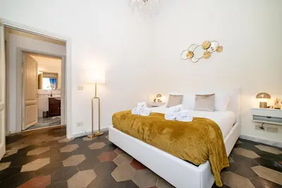 a white bedroom with a bed with towels on it at Stella Luxury House - Lombardia in Rome