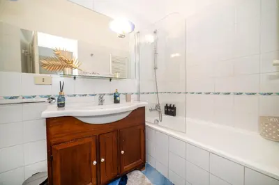 a bathroom with a sink and a tub and a mirror at Stella Luxury House - Lombardia in Rome