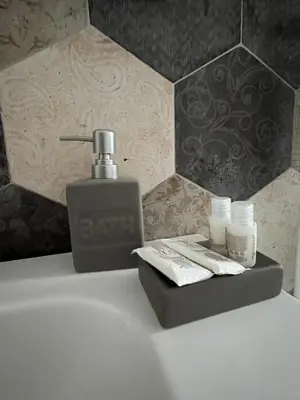 a bathroom with a sink with a soap dispenser and a bottle of soap at Urban Corner in Rome