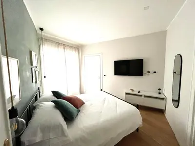 a white bedroom with a bed and a television at Urban Corner in Rome
