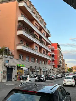 a large building with cars parked on the side of a street at Urban Corner in Rome