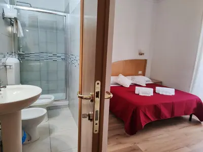 a bathroom with a bed and a sink and a toilet at Guest House Rome Termini Station in Rome
