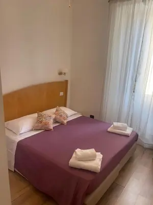 a bedroom with a purple bed with towels on it at Guest House Rome Termini Station in Rome