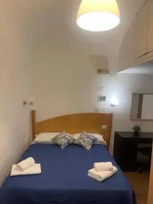a bedroom with a blue bed with two towels on it at Guest House Rome Termini Station in Rome