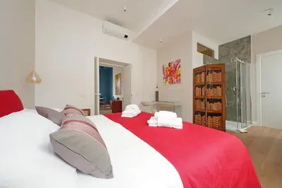 a bedroom with a red and white bed with towels on it at Scipioni2 in Rome