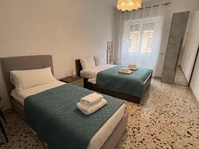a room with two beds and a mirror in it at C D Candia Apartment in Rome