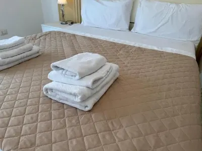 a bed with towels sitting on top of it at C D Candia Apartment in Rome