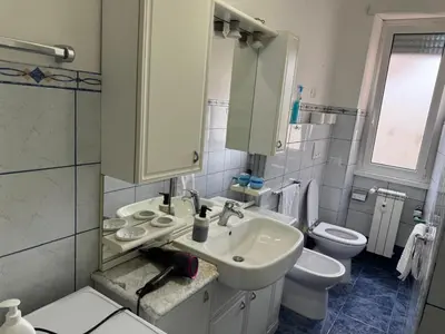a white bathroom with a sink and a toilet at C D Candia Apartment in Rome