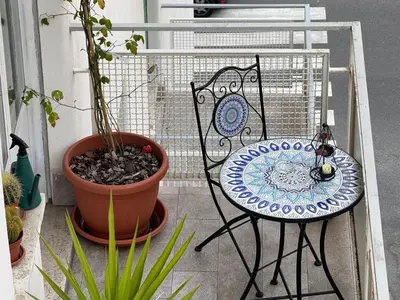 a table and chair on a balcony with plants at C D Candia Apartment in Rome