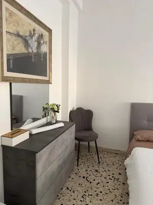 a bedroom with a desk with a chair and a painting at C D Candia Apartment in Rome