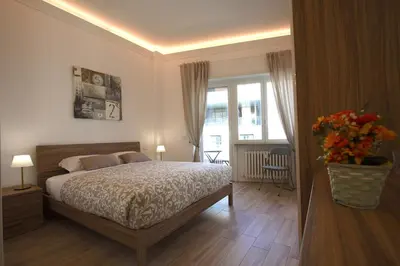 a bedroom with a bed and a vase of flowers at Vigna Clara 2BR Holiday House in Rome