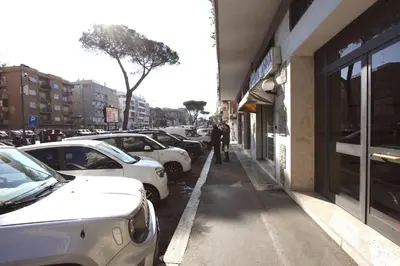 a man walking down a sidewalk next to parked cars at Vigna Clara 2BR Holiday House in Rome
