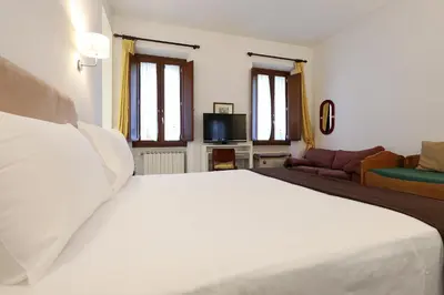 a bedroom with a large white bed and a couch at Piazza Navona in Rome