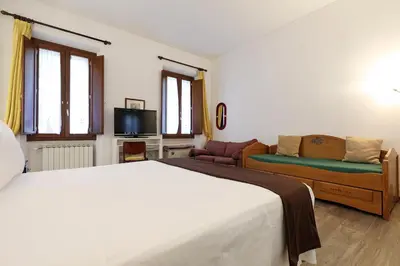 a bedroom with a bed and a couch and a tv at Piazza Navona in Rome
