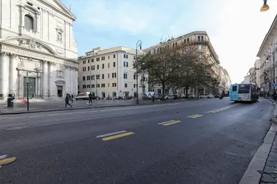 a blue bus driving down a city street with buildings at Piazza Navona in Rome