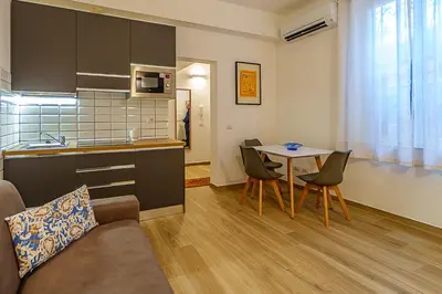 a kitchen and a living room with a table and chairs at Casa Cesari in Rome