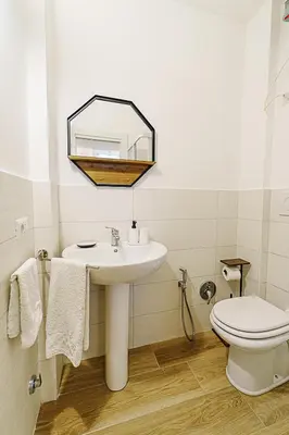 a bathroom with a sink and a toilet and a mirror at Casa Cesari in Rome