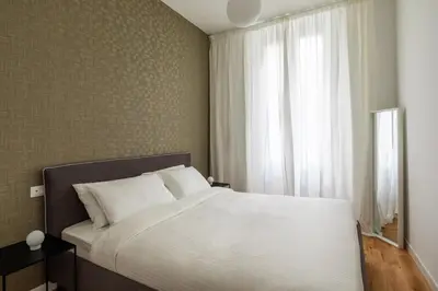 a bedroom with a large white bed and a window at Casa Dante in Rome