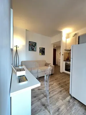 a living room with a couch and a table and a refrigerator at Sweet Home Acaia - San Giovanni in Rome