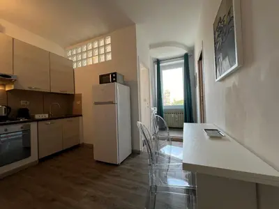 a kitchen with a white refrigerator and a table at Sweet Home Acaia - San Giovanni in Rome