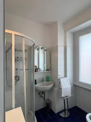 a white bathroom with a sink and a shower at Sweet Home Acaia - San Giovanni in Rome