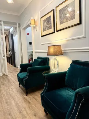a living room with two green couches and a lamp at Rome Piazza di Spagna Guesthouse in Rome