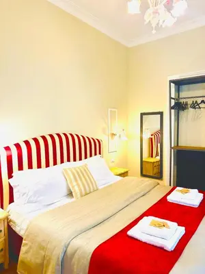 a bedroom with a large bed with red and white stripes at Rome Piazza di Spagna Guesthouse in Rome
